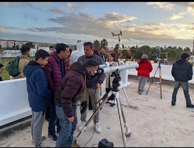 يقوم فريق من المعهد الوطني للرصد الجوي بمراقبة هلال شهر رمضان لعام 1447 هـ في الكاف. ويتجمع الناس حول تلسكوب، ومن المرجح أنهم يشاركون في عملية الرصد.